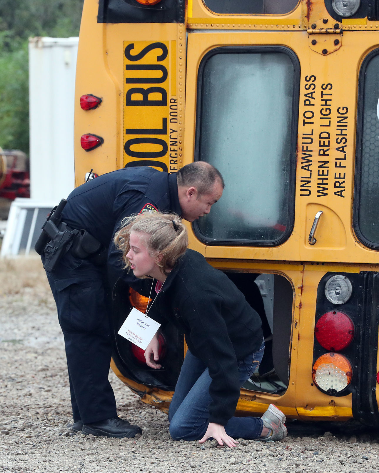 Officer helps student from overturned bus during crisis drill